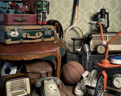 Assorted vintage items in the attic with retro wallpaper background.